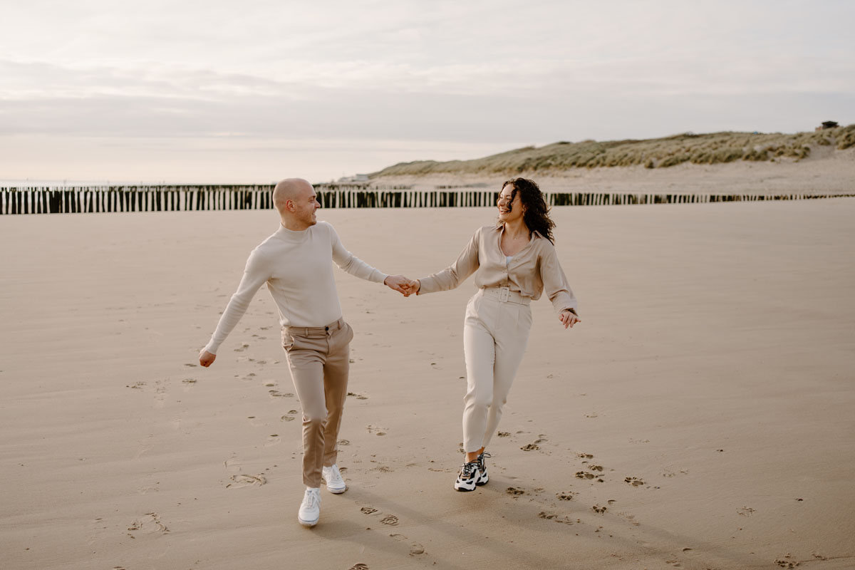 koppel rennend over het strand in vlissingen